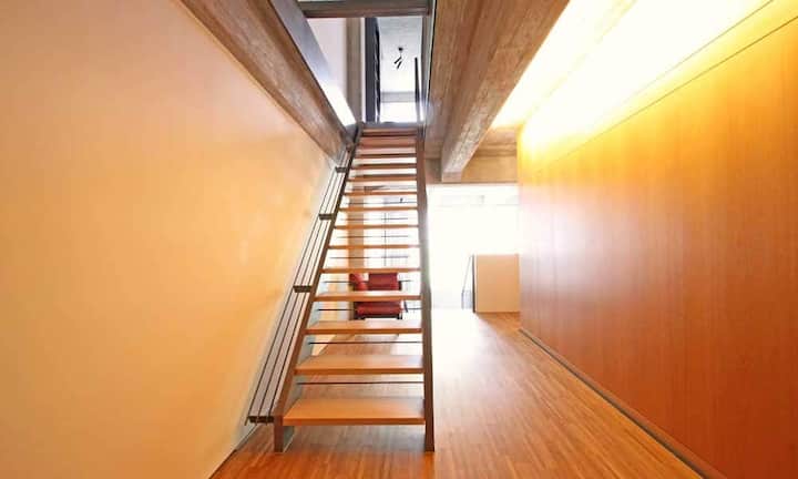 Im Innern wurde durch die Kombination verschiedener Materialien wie Sichtbeton, Stahl und Eisen der industrielle Charme beibehalten. Im Kontrast dazu stehen warme Holztöne beim Bodenbelag und bei den Einbauten.