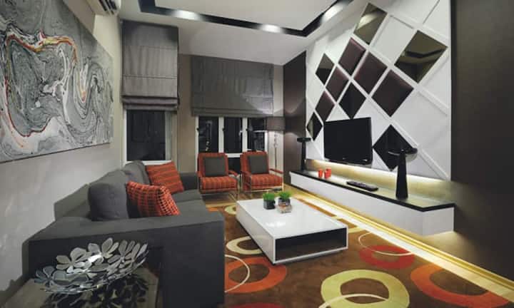 Elegant: Bunte Kreise auf dem Boden setzen im quadratisch dekorierten Wohnzimmer frische Akzente.