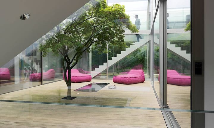 Akzentuiert: Die rosaroten Loungekissen bringen starke Farbakzente in den Lichthof, der in der Übergangszeit rege genutzt wird.