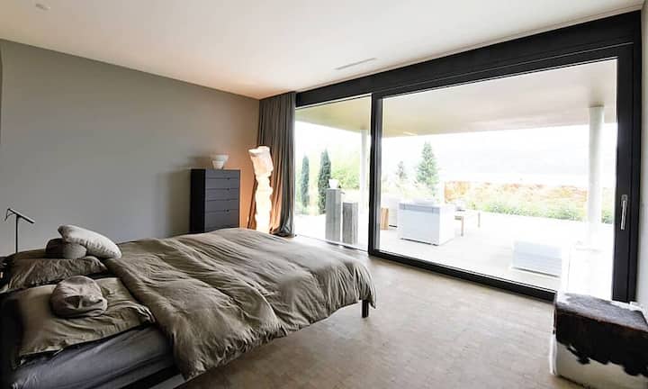 Im unteren Stockwerk befindet sich das Hauptschlafzimmer, welches direkten Zugang zu der Terrasse sowie zum Infinity-Pool bietet.