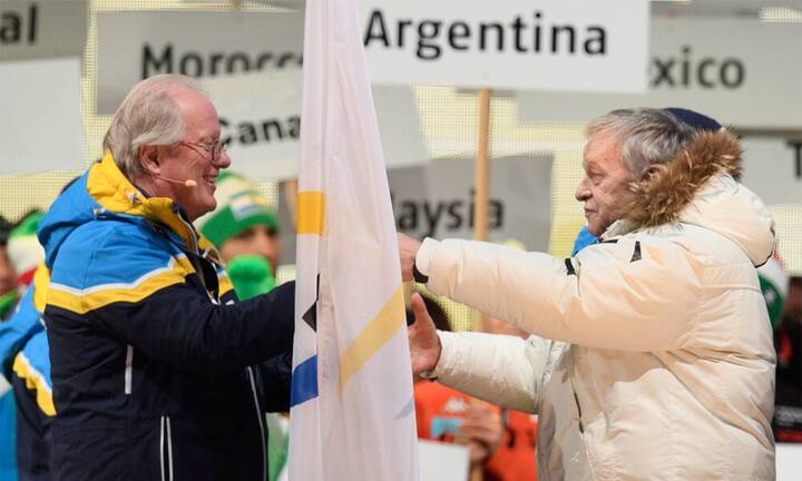 FIS-Präsident Gian Franco Kasper übergibt die Fahne an den Präsidenten des Organisationskomitees Hugo Wetzel. Wie die Tafeln im Hintergrund zeigen, gibt es auch im Skisport Exoten. So sind etwa Malaysia, Marokko und Mexiko mit dabei.
