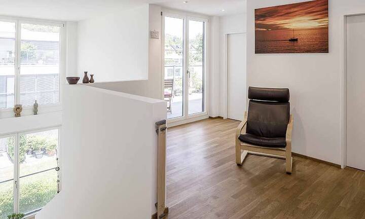 Der Wohnbereich ist bewusst offen und weiträumig gehalten. Grosse Fensterfronten sorgen für Transparenz und Helligkeit.