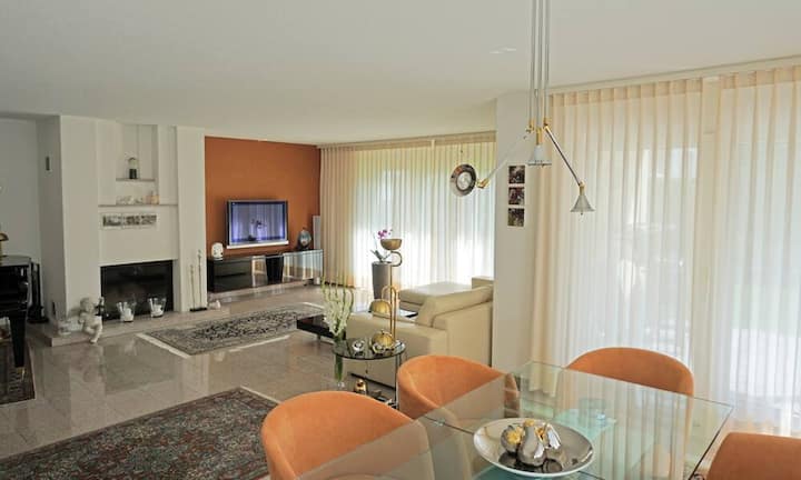 Das Wohnzimmer grenzt an den Essbereich und verfügt über ein Warmluft-Cheminée.