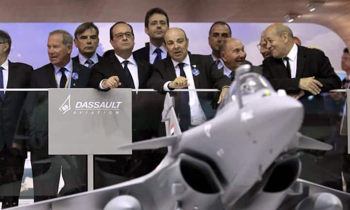 Der Französische Präsident Francois Hollande hört sich die Erklärungen vom Dassault Aviation Chairman Eric Trappier an.