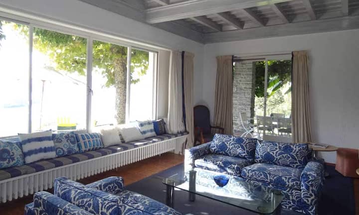 Ein helles Entrée mit Blick auf die Brissago-Inseln begrüsst beim Eintritt in die Villa. Wohnen und Schlafen wurden in der Liegenschaft bewusst voneinander getrennt. Vom nach Süden ausgerichteten Wohn-Esszimmer mit Cheminée und Portico, gelangt man in die Parkanlage.