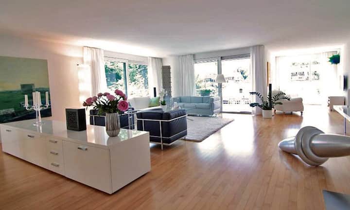 Nach dem Eintreten steht man im sehr grosszügigen Wohnzimmer mit raumhohen Fensterflächen.