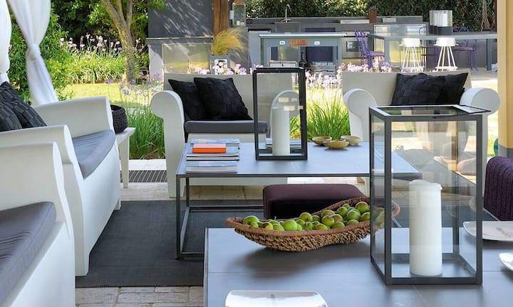 Innenraum: Der alte Boden aus Pietra-Naturstein vom nahen Monte Amiata verleiht dem Wohnzimmer Lokalkolorit. Die Sessel sind Vintage-Stücke aus den zwanziger Jahren, das Büchergestell Ptolomeo ist von Bruno Rainaldi und die Deckenlampe Zettel von Ingo Maurer.