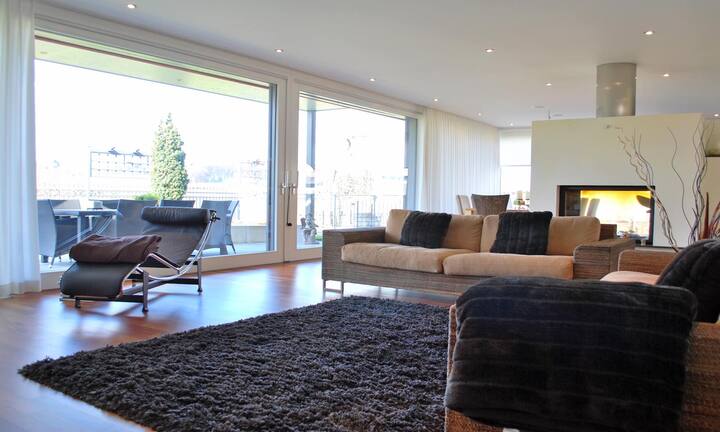 Zur Terrasse gelangt man durch die grossen Glastüren im  Wohnzimmer mit Cheminée. Speziell an der Villa ist...