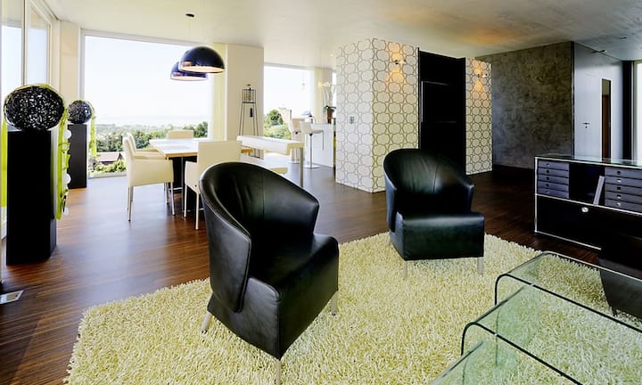 ...grenzt an und ist durch eine Bar getrennt. Auch der Ess- und Wohnbereich ist offen und grosszügig konzipiert.