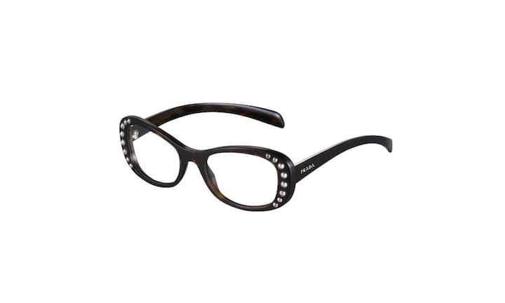 Üppig: Prada (Frau). Mit einer schmalen Silhouette und Verzierungen entlang der abgerundeten Kontur ist diese eigenwillige Brille in den Varianten Schwarz, Schildpatt und Elfenbein erhältlich. Preis 583 Franken