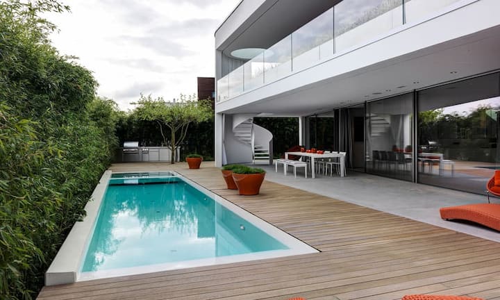 Abgeschirmt: Auf der vor Einblicken geschützten Terrasse mit Pool und Gartenmöbeln von Paola Lenti lässt sich unbeschwert entspannen.