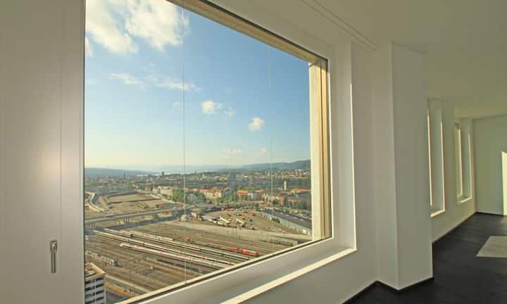 Sieben Fenster im Wohn- und Essbereich bieten unverbauten Blick auf die Stadt und eine helle Atmosphäre.