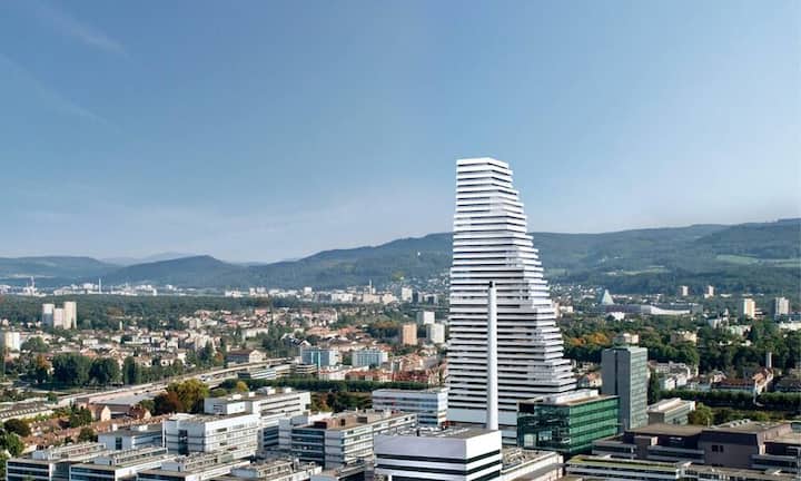 Roche-Hauptsitz, Basel, Herzog & de Meuron, 2015: Die Novartis-Konkurrentin Roche zieht es statt in die Breite in die Höhe. Mit einem weit nach oben sich verjüngenden Treppenturm prägt der Konzern Stadt und Land seinen Anspruch ein: Wir sind die Grössten, die Höchsten und die Wohlhabendsten.