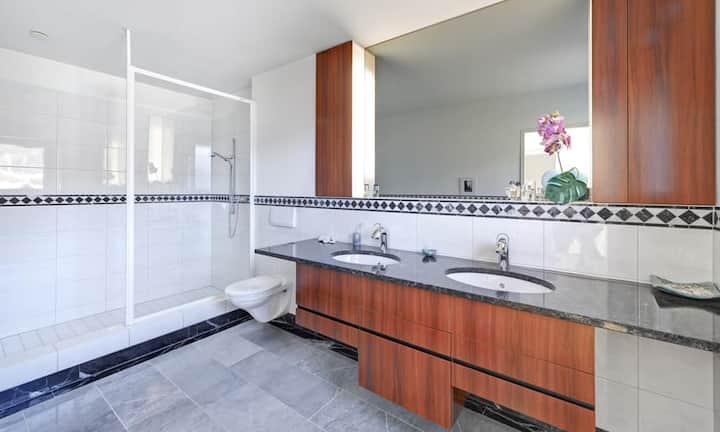 Das geräumige Bad ist mit erlesenen Materialien wie beispielsweise dem Waschtisch aus Granit ausgestattet.