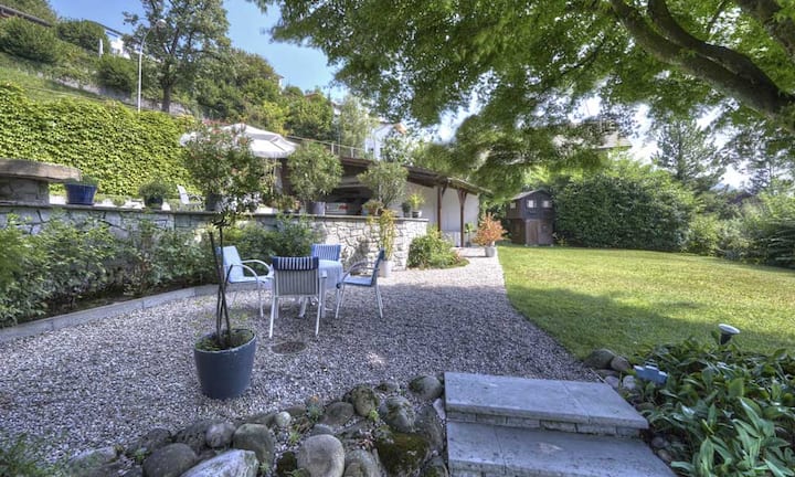 Eine gepflegte Gartenanlage mit gedecktem Sitzplatz laden zum verweilen ein.