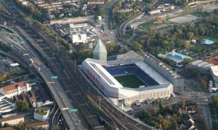 Viel Erfahrung haben Herzog & de Meuron im Bau von Stadien. 1998 bis 2001 bauten sie den St.-Jakob-Park in Basel. Der kristallförmige Turm kam im Zuge der Erweiterung für die EM 2008 dazu. Wikimedia/CC/Sven Scharr