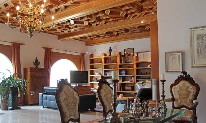 Das Wohn- und Esszimmer mit barocken Einrichtungen ist durch eine eindrückliche Tür zugänglich, die aus einem Schloss stammt.