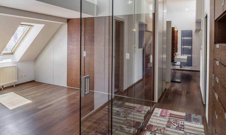 Auf der linken Seite der Wohnung befinden sich nebeneinander die drei geschlossenen Zimmer. Zuvorderst ein Gästezimmer, daneben ein Arbeits- oder Fitnesszimmer mit 3 Meter hohen Glaswänden.