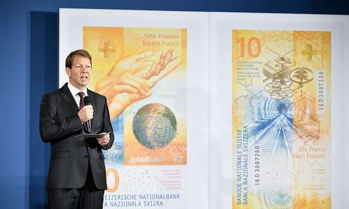 SNB-Vizedirektor Fritz Zurbrügg präsentiert den 10-Franken-Schein: Auf dem neuen Zehner dreht sich alles das Organisationstalent der Schweiz. Auf der Vorderseite ist ein Globus mit den Zeitzonen zu sehen, auf der Rückseite ist ein Uhrwerk abgebildet. Ebenfalls zu sehen ist ein Eisenbahntunnel, der laut Zurbrügg für die Schweizer Ingenieurskunst stehen soll.