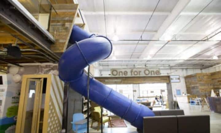 Toms, Los Angeles: Im Büro des Schuhherstellers Toms in Los Angeles wurde eine blau lackierte Rutsche installiert, daneben stehen Schilder mit Sprüchen, die die Motivation steigern sollen. Ausserdem ist das Büro sehr hundefreundlich.