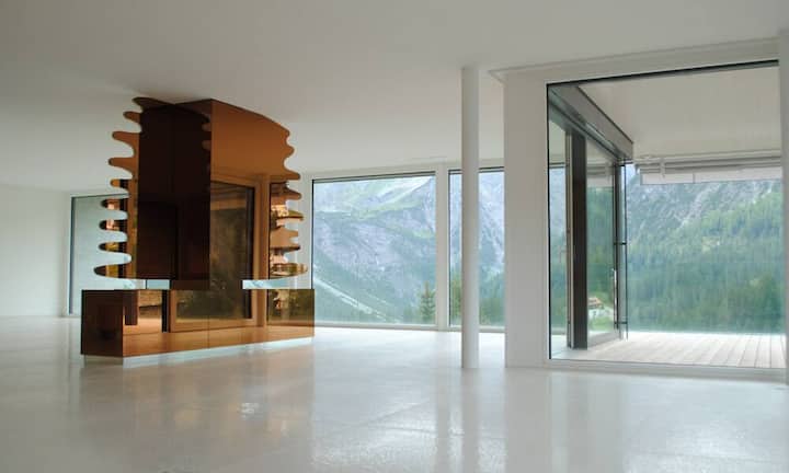 Der grosszügige Wohn- und Essbereich ist durch einen Raumtrenner in Form einer Tanne mit Petroleumfeuer abgegrenzt.