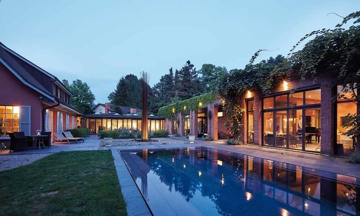 Im Einklang mit der Parkanlage ist das Anwesen eine Verschmelzung aus zeitgenössischer Architektur und eleganter Wohnkultur. Highlight ist der beheizte Infinity-Pool.