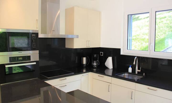 Im Obergeschoss findet sich ausserdem die Küche und das Esszimmer. Auf dieser Ebene hat man Ausblick über das Tal. Des Weiteren befindet sich im Obergeschoss ein Schlafzimmer mit Bad en suite sowie eine zusätzliche Gästetoilette.