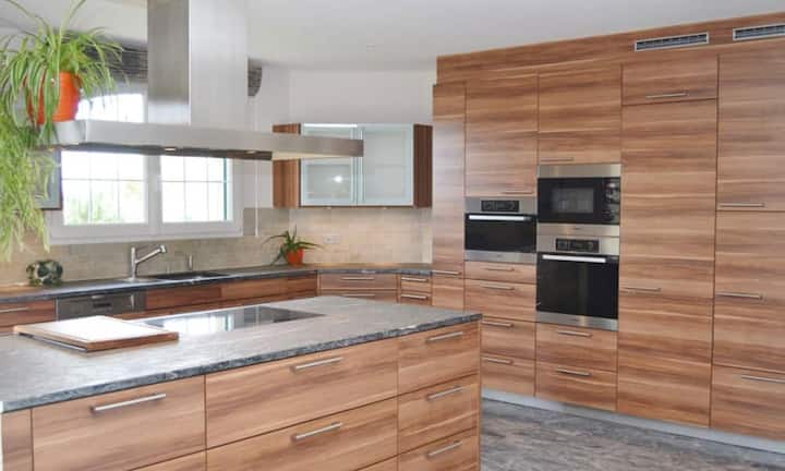 In der geschlossenen Küche befinden sich moderne Gerätschaften und genügend Stauraum.