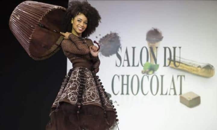Mit seiner 20. Ausgabe lockt der Salon du Chocolat als weltweit grösste Schokoladenmesse wieder nach Paris. Zum Auftakt steckten die Schokoladenexperten Models in tragbare Kostümfantasien aus Schokolade. Ein Model präsentierte dabei ein süsses Abendkleid, mit passendem Regenschirm für Regentage. Entworfen hat die Outfits Designerin Patrice Chapon.