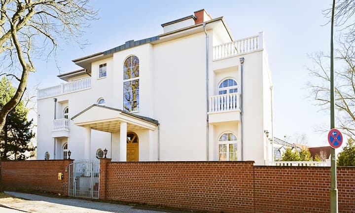 Diese Villa steht im Ortsteil Dahlem, gelegen im grünen Süd-Westen von Berlin. Die Wohngegebnd gehört zu den beliebtesten und begehrtesten Wohnlagen der Hauptstadt.
Engel & Völkers