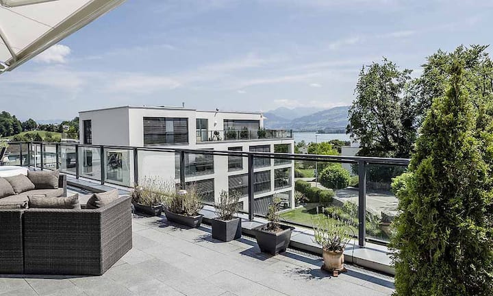 Von der fast 100 Quadratmetern grossen Terrasse der Attikawohnung aus hat man Aussicht auf die umliegende Berglandschaft sowie den Zürichsee.