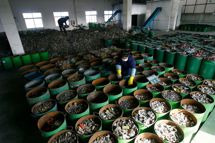 Workers sort batteries in an electronic waste recycling factory in Jingmen, Hubei province December 3, 2009. VCP (Photo by Jie Zhao/Corbis via Getty Images)