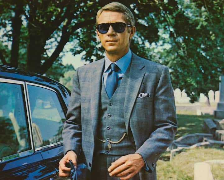 Steve McQueen (1930-1980), US actor, wearing sunglasses with a grey suit, a blue shirt and dark blue tie in a publicity image issued for the film, 'The Thomas Crown Affair', USA, 1968. The crime drama, directed by Norman Jewison, starred McQueen as 'Thomas Crown'. (Photo by Silver Screen Collection/Getty Images)