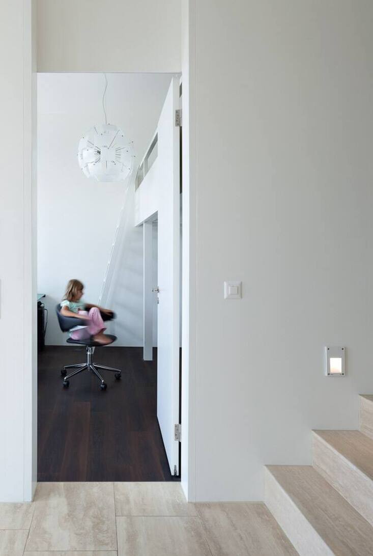 Mit dunklem Holz und hellen Steinplatten sind auch die Böden auf der Schlafebene der Söhne gestaltet.