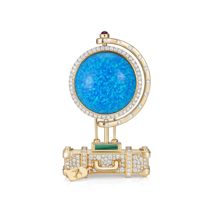 <p>«All around the World»-Globus aus Opal auf einem goldenen Köfferchen.</p>