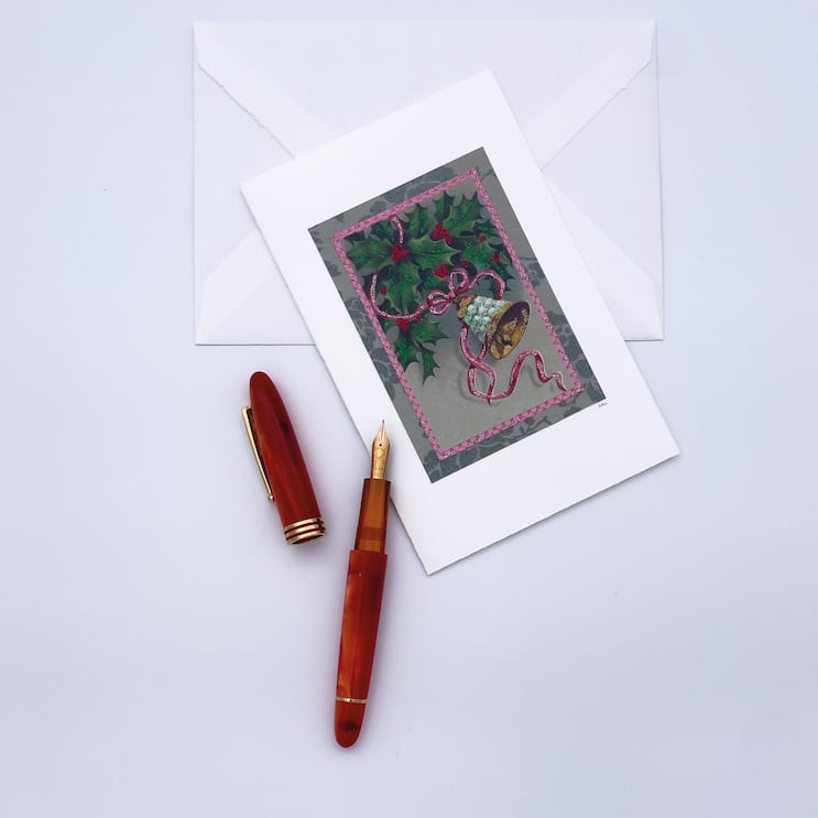 Weihnachtskarte und ein roter Stift liegen zum Schreiben bereit.