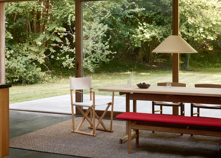 Praktische sommerliche Klappstühle und eine Bank ergänzen einen langen Tisch und die Stühle. So können Sie mehr Gäste für spontane grössere Einladungen platzieren. www.fredericia.com